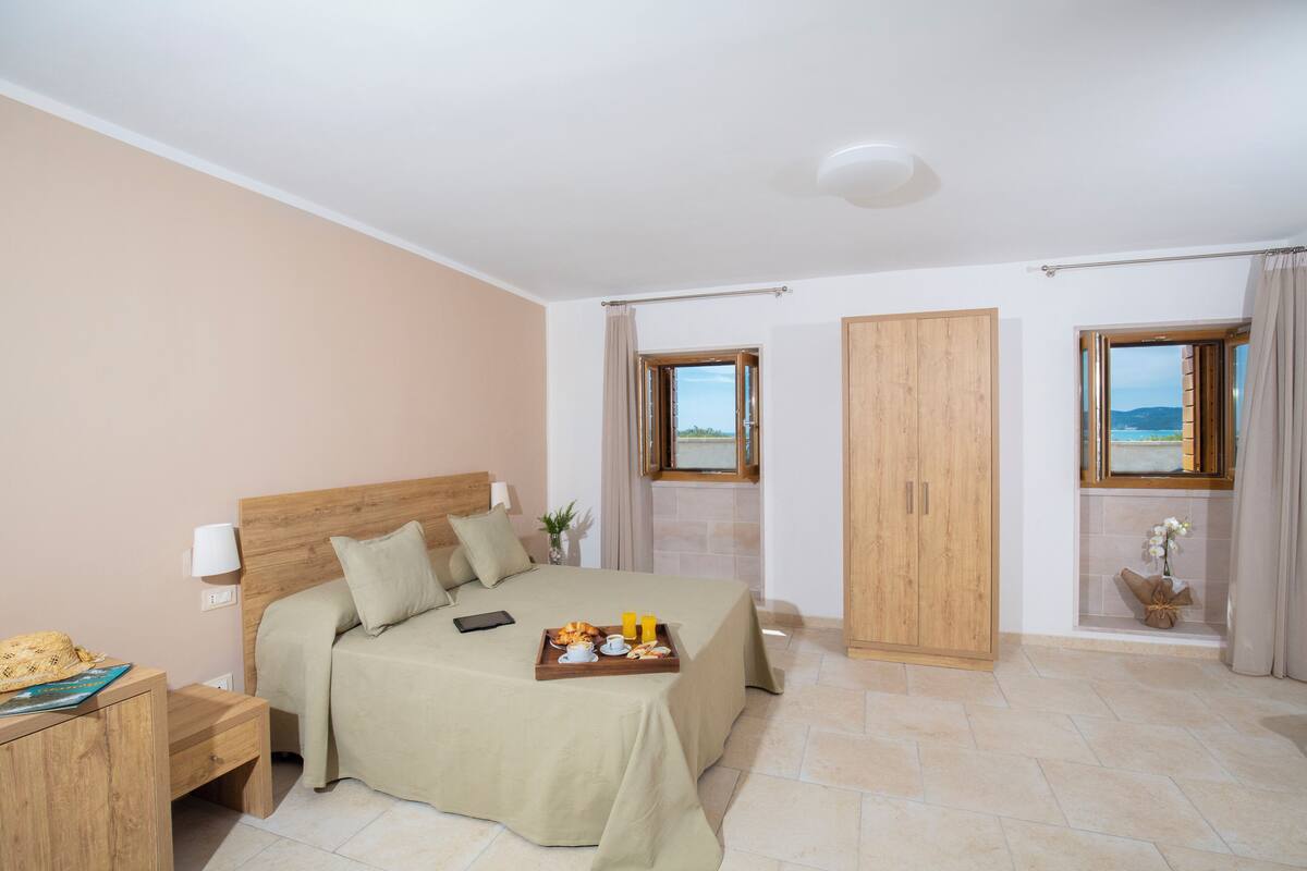 Un dormitorio con cama, mesita de noche y ventana con vistas.