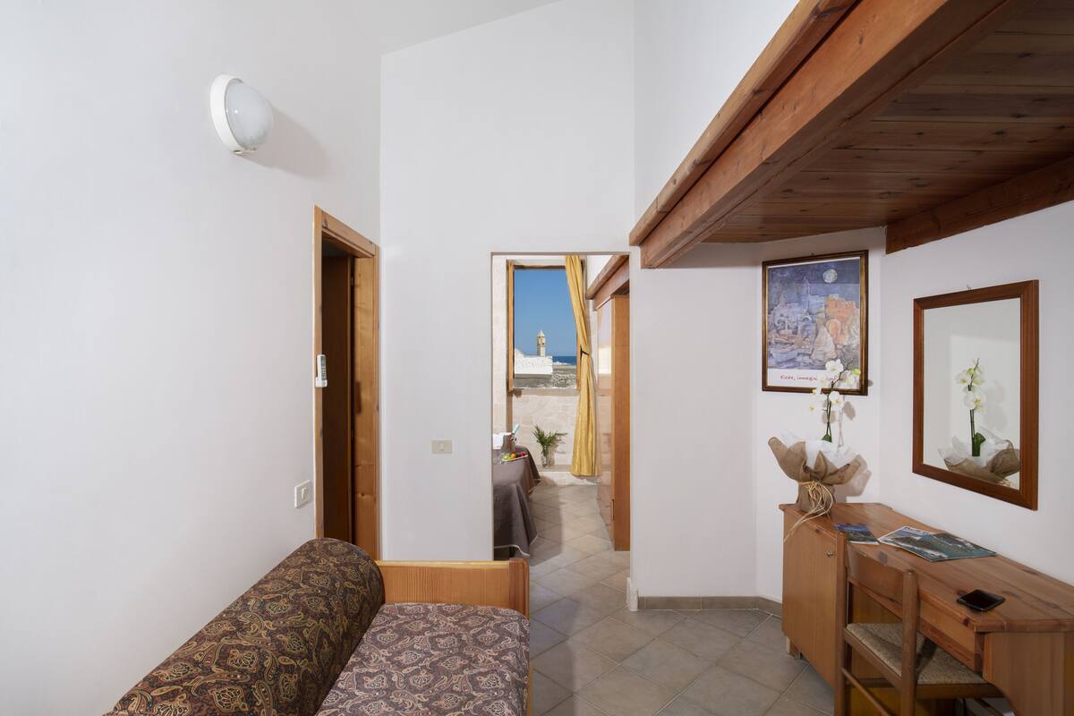 Una habitación con cama, escritorio y vista al exterior.