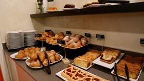 Un bufé con diversas opciones de productos horneados, incluyendo pasteles, tartas y bizcochos.