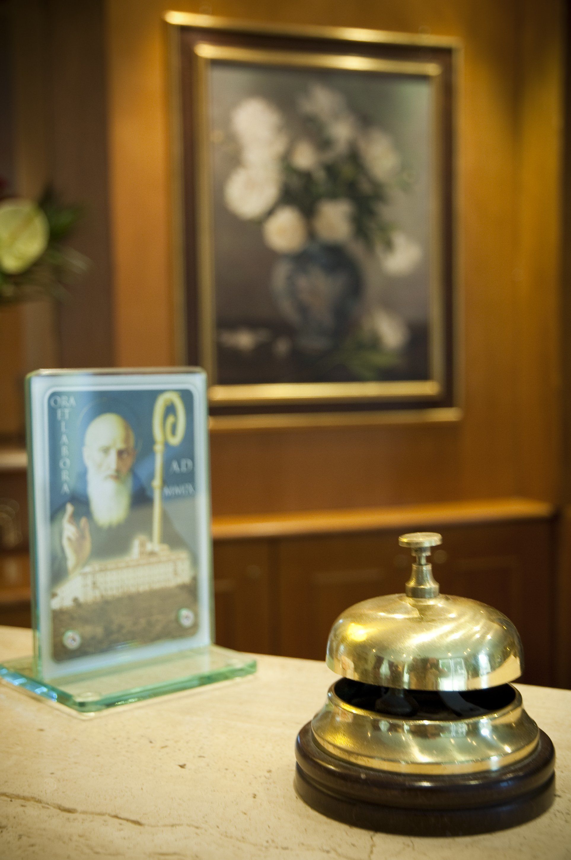 A reception area with a glass display case containing a framed portrait and a silver bell on a wooden base.