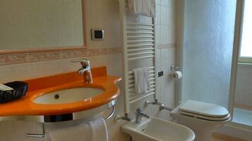A bathroom with a white sink, a bidet, and a toilet.