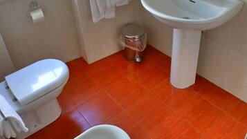 Un baño con inodoro, lavabo y bidé.