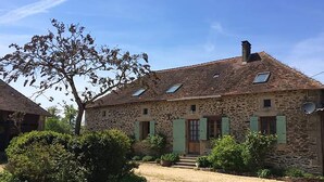 A stone house with a sloped roof, green shutters, and a small front porch. - The Alpaca B&B (Chalais)