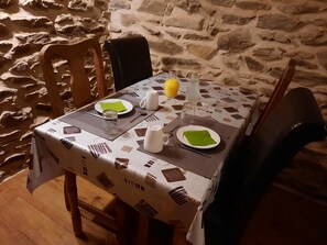 Una mesa de comedor dispuesta con platos, cubiertos y un florero.