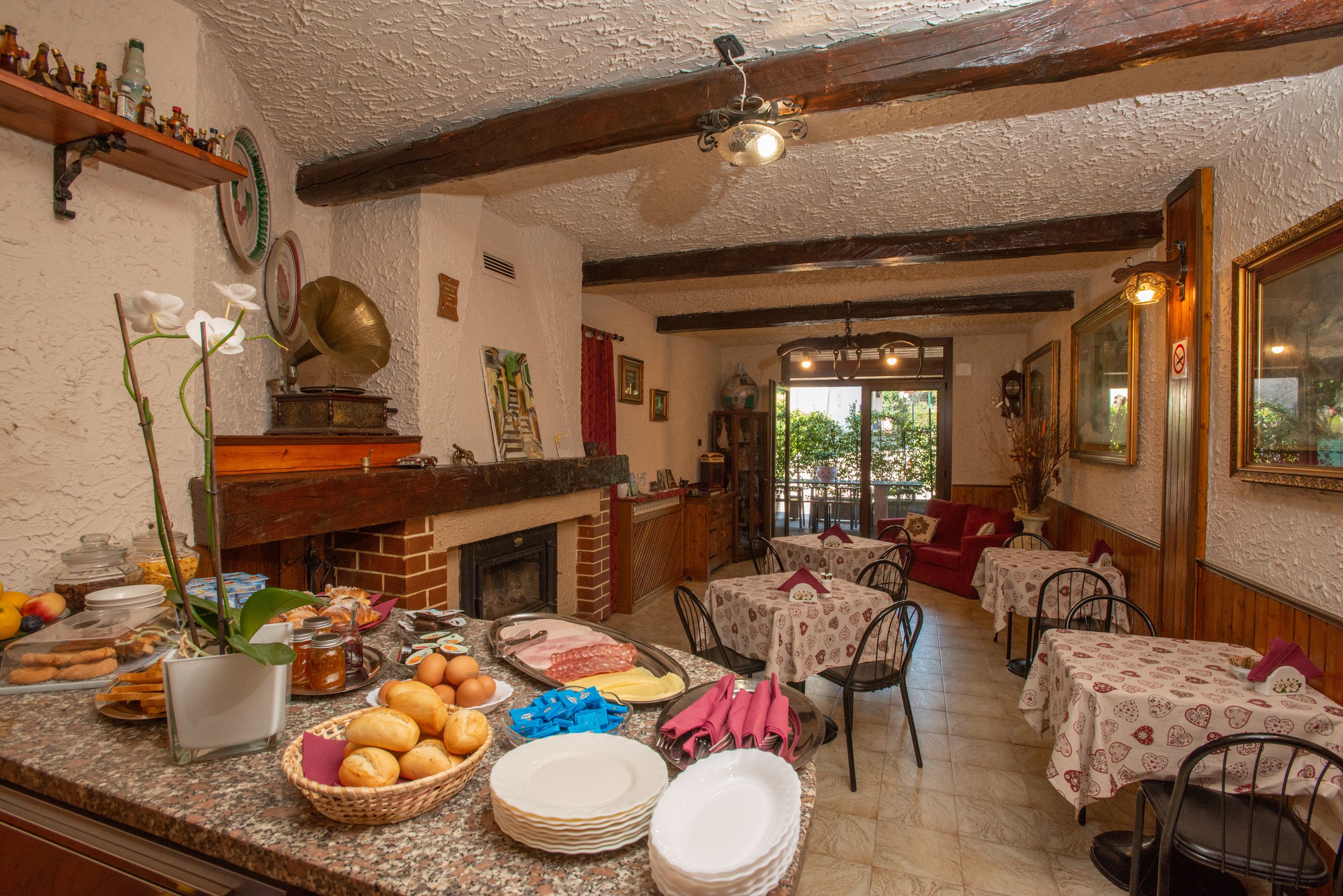 A dining area with tables, chairs, and a fireplace.