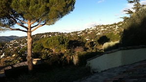 A tree-lined hillside with a view of a town in the background. - La Pelicane (Mougins)