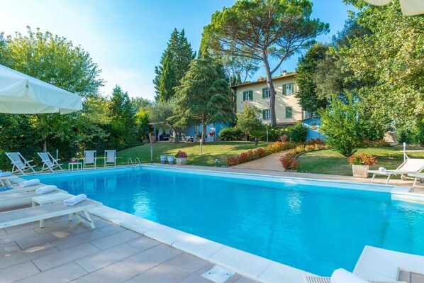 Una piscina al aire libre, tumbonas