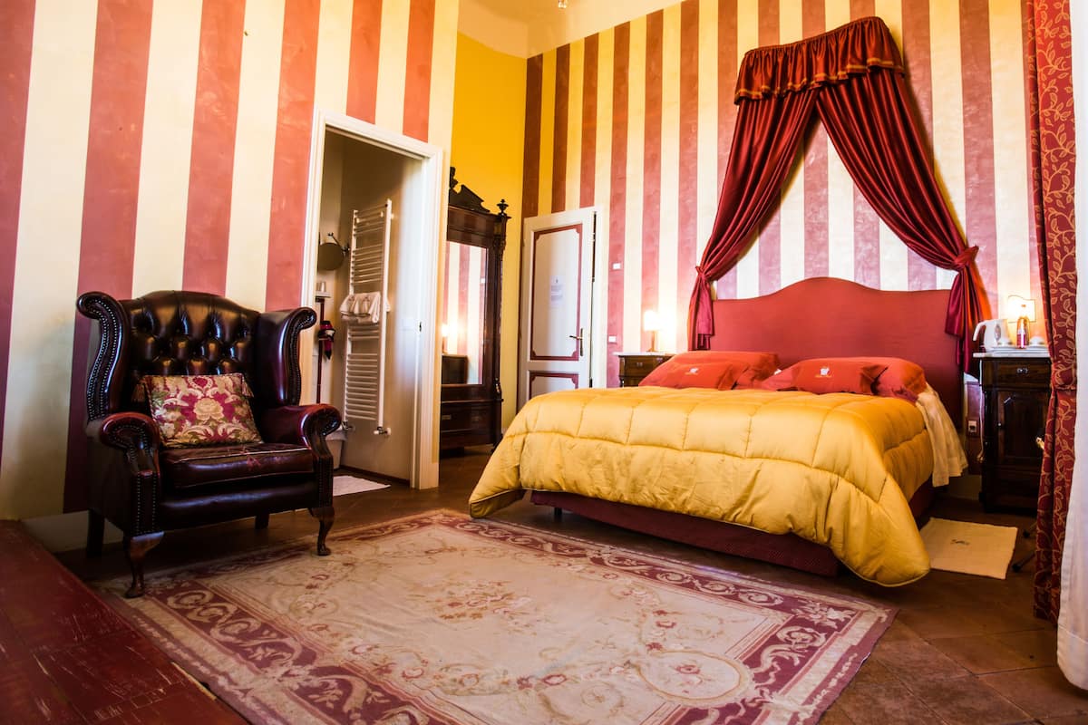 Une chambre à coucher avec un grand lit, une chaise et une armoire.