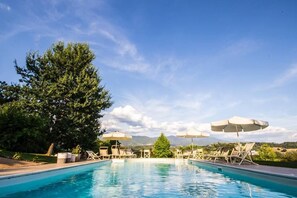 Una piscina al aire libre, tumbonas
