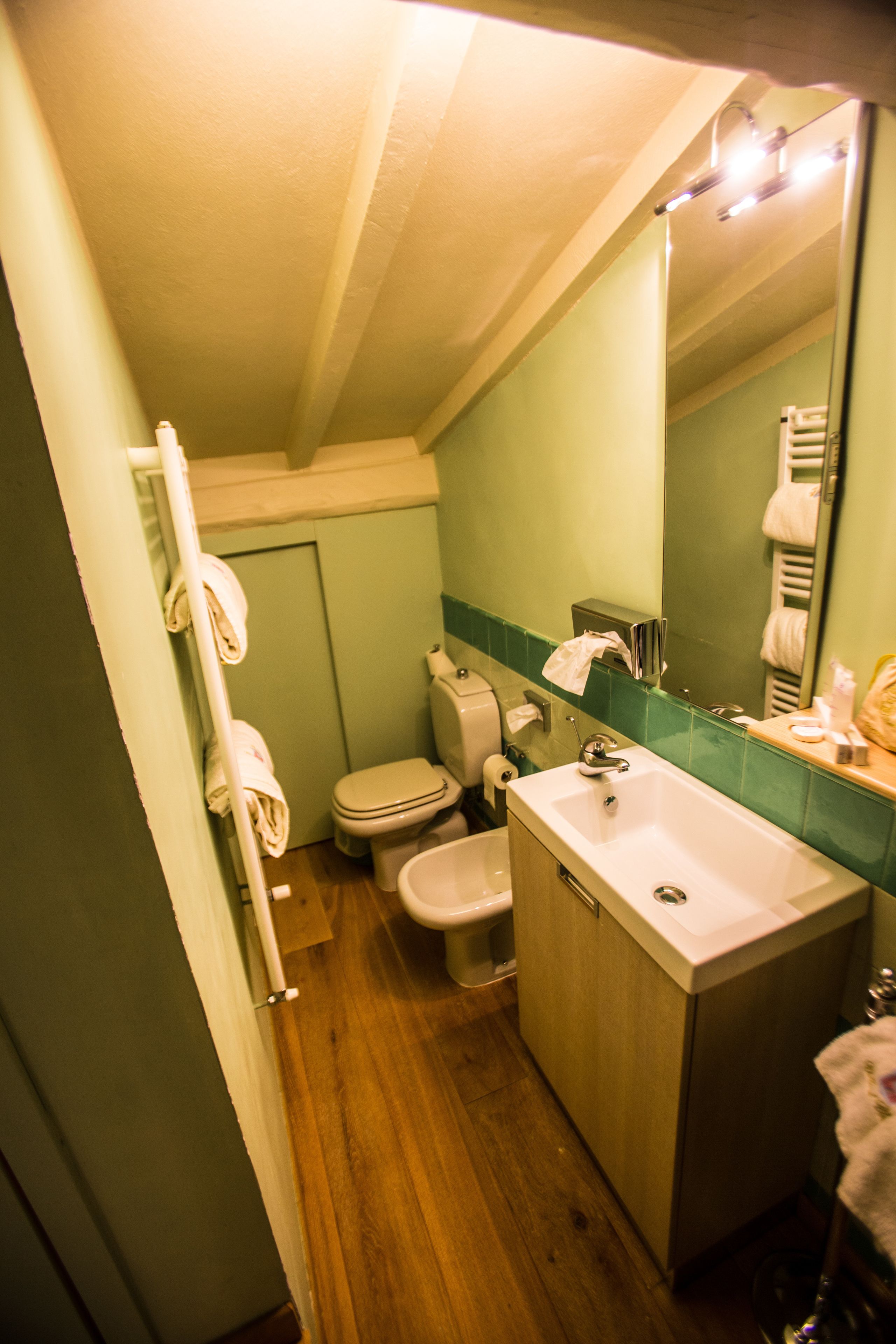 Ein kleines Badezimmer mit Toilette, Waschbecken und Spiegel.