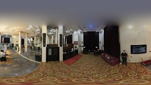 A spacious lobby with a reception desk, seating area, and a patterned carpet. - Treasures Suites & Conferences (Abuja)