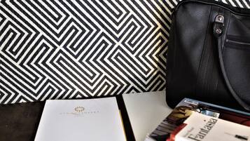 A black leather bag, a white booklet with 'Cinqués' logo, and a magazine titled 'Fantasia'.