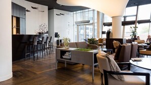 Un interior moderno con una zona de bar, asientos y ventanas amplias.