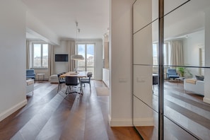 En moderne lejlighed med spiseplads, opholdstue og en balkon med udsigt.