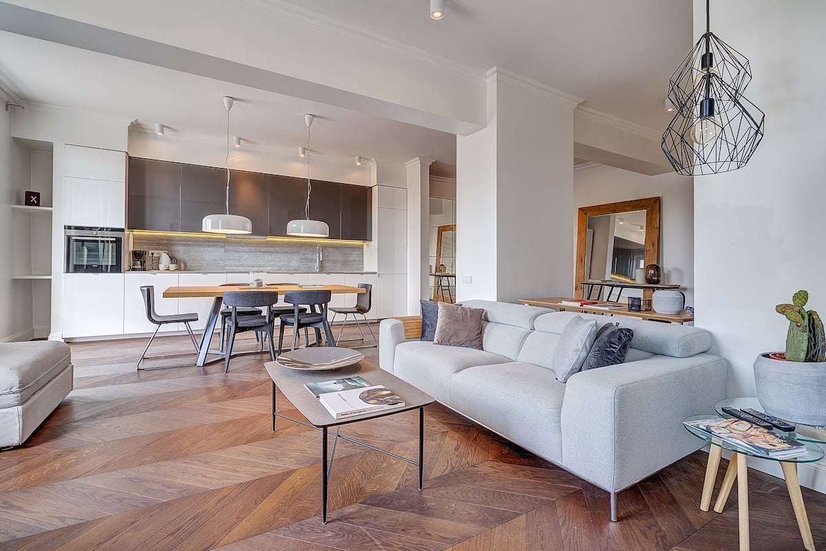 Una sala de estar moderna con sofá, mesa de centro y comedor.