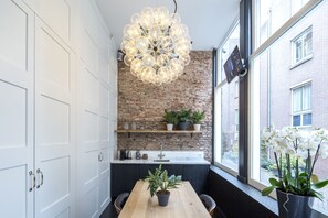 Enjoy cooking in this well-equipped kitchen with a central island, brick accent wall, and large window offering a view of the outside.