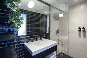 Features a sleek tile design, large mirror, and a handheld showerhead.