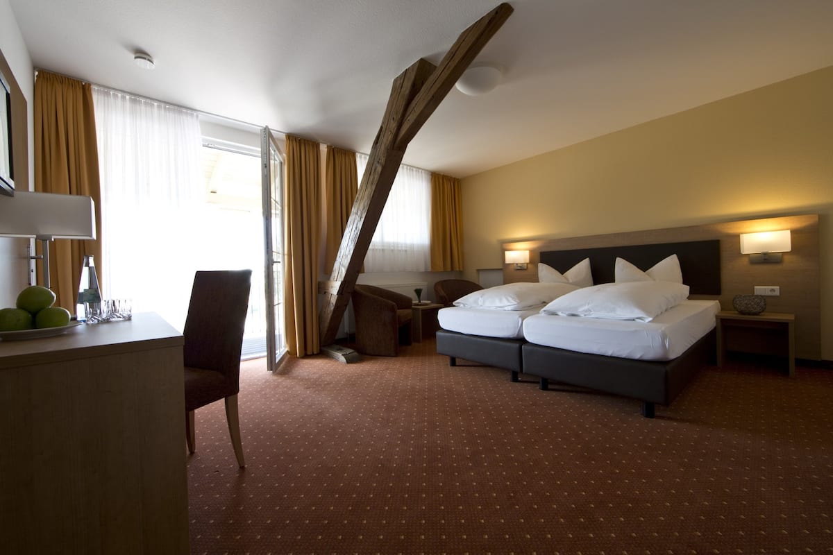 A hotel room with a bed, a desk, and a chair.