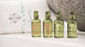 Four bottles of Greek Olive Tree shampoo with olive oil on a white surface.