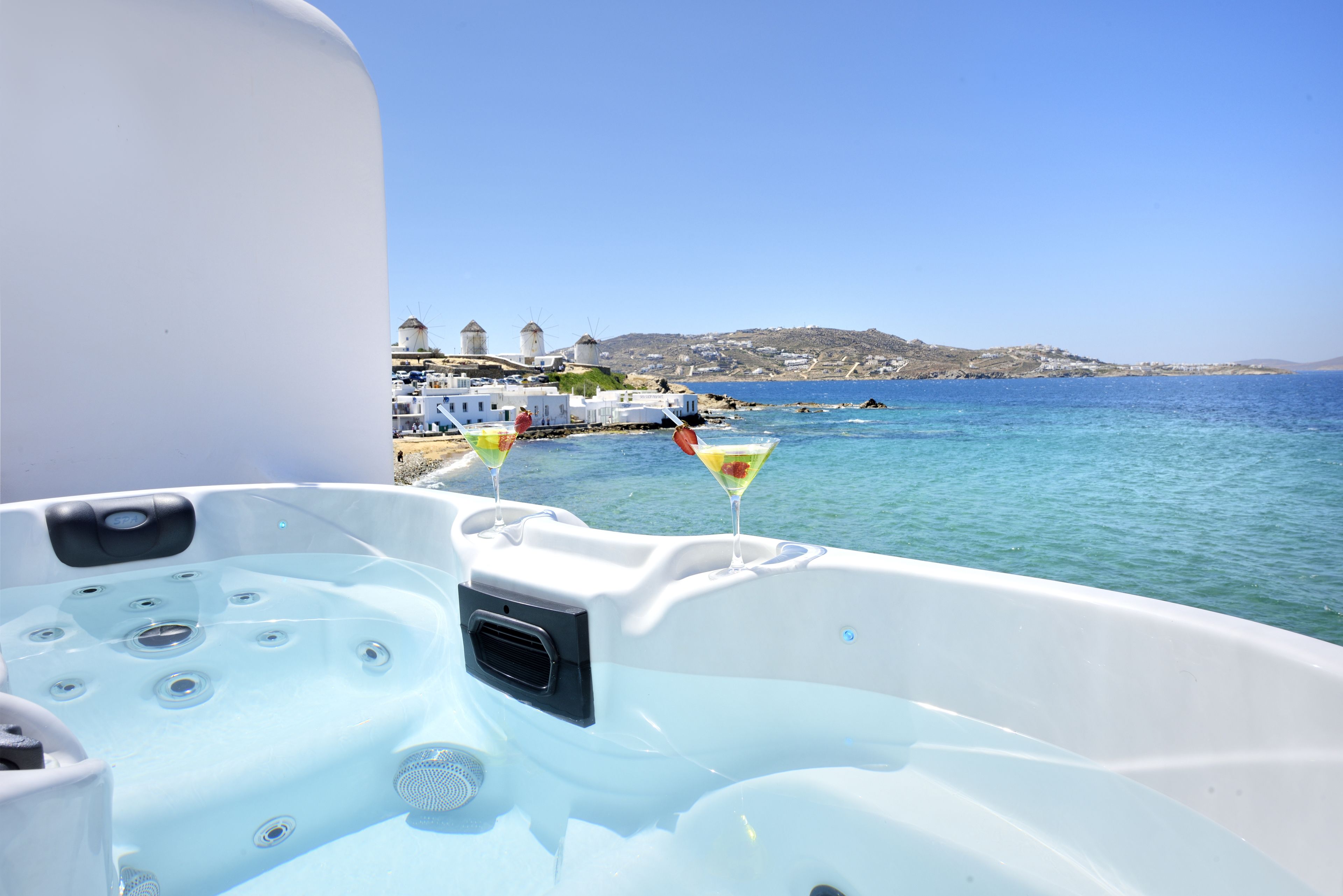 A hot tub with a clear view of a coastal town and buildings in the background.