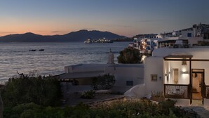 A coastal view with a boat, buildings, and a mountain in the background.
