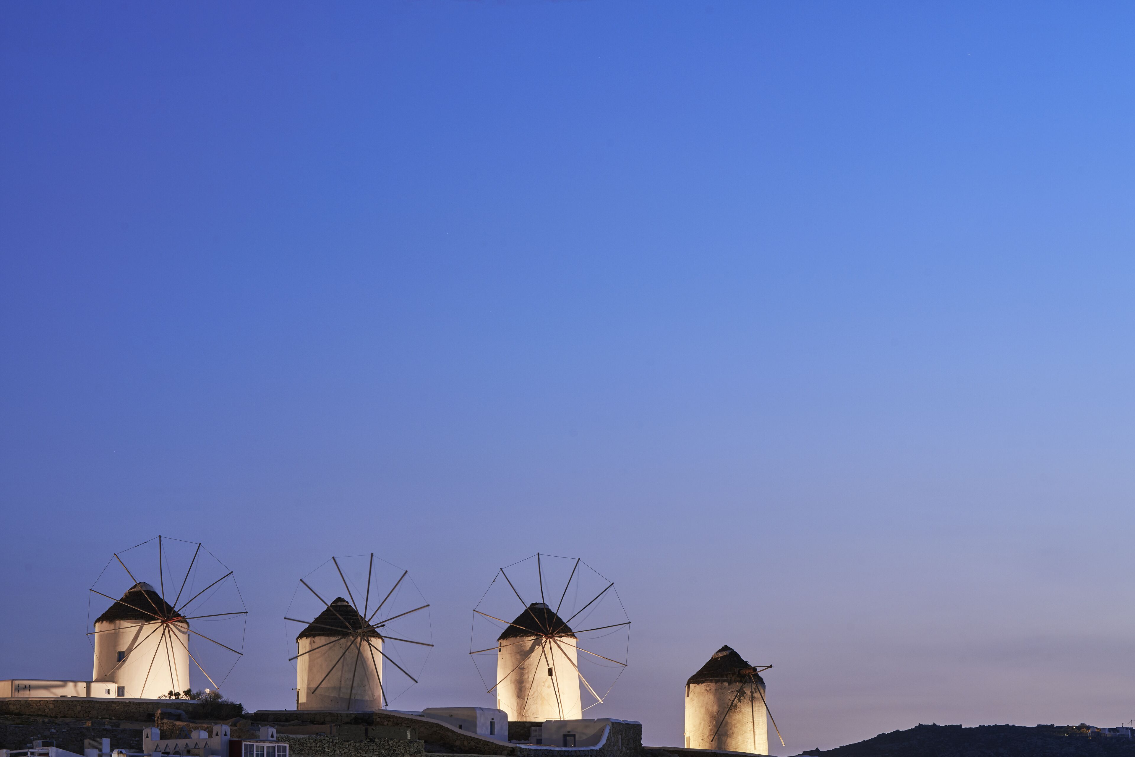 Three windmills with a clear sky in the background.