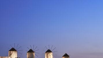 Three windmills with a clear sky in the background.