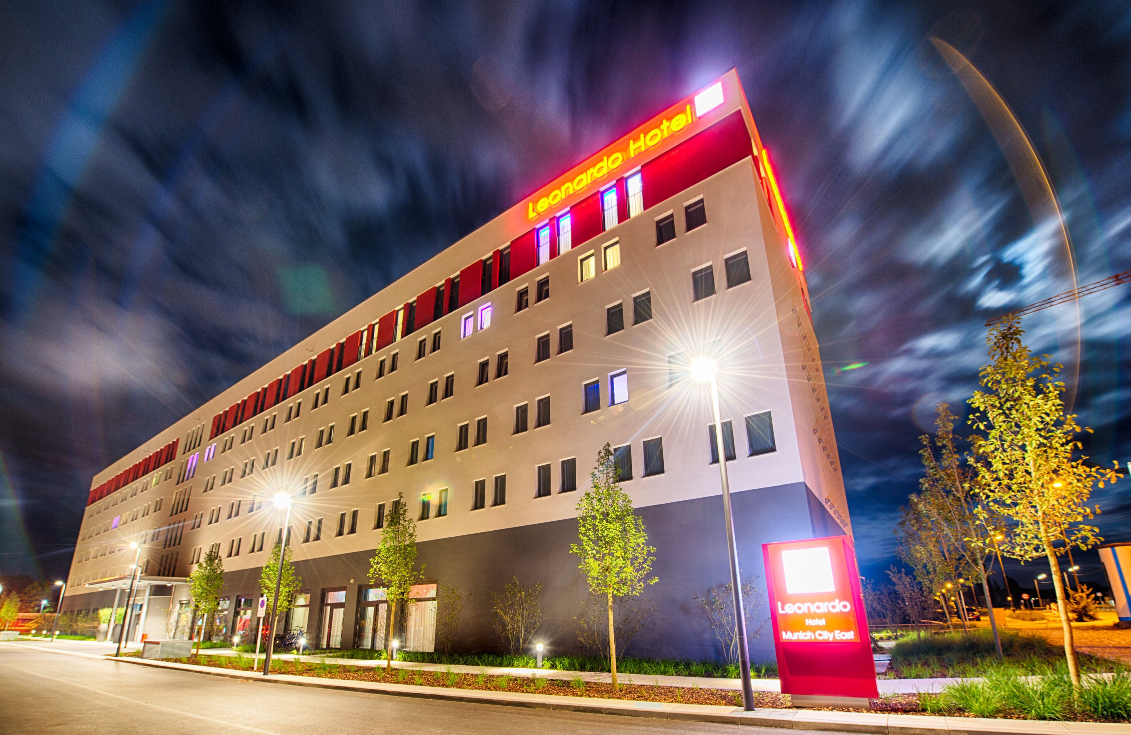 Ein modernes Hotelgebäude mit mehreren Etagen, einer gut sichtbaren Hotelschild und einer gut beleuchteten Fassade.