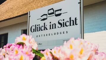 A sign with the text 'Glück in Sicht' and 'OSTSEELODGES' indicating a lodging establishment.