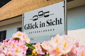 A sign with the text 'Glück in Sicht' and 'OSTSEELODGES' indicating a lodging establishment. - Glück in Sicht (Gluecksburg)