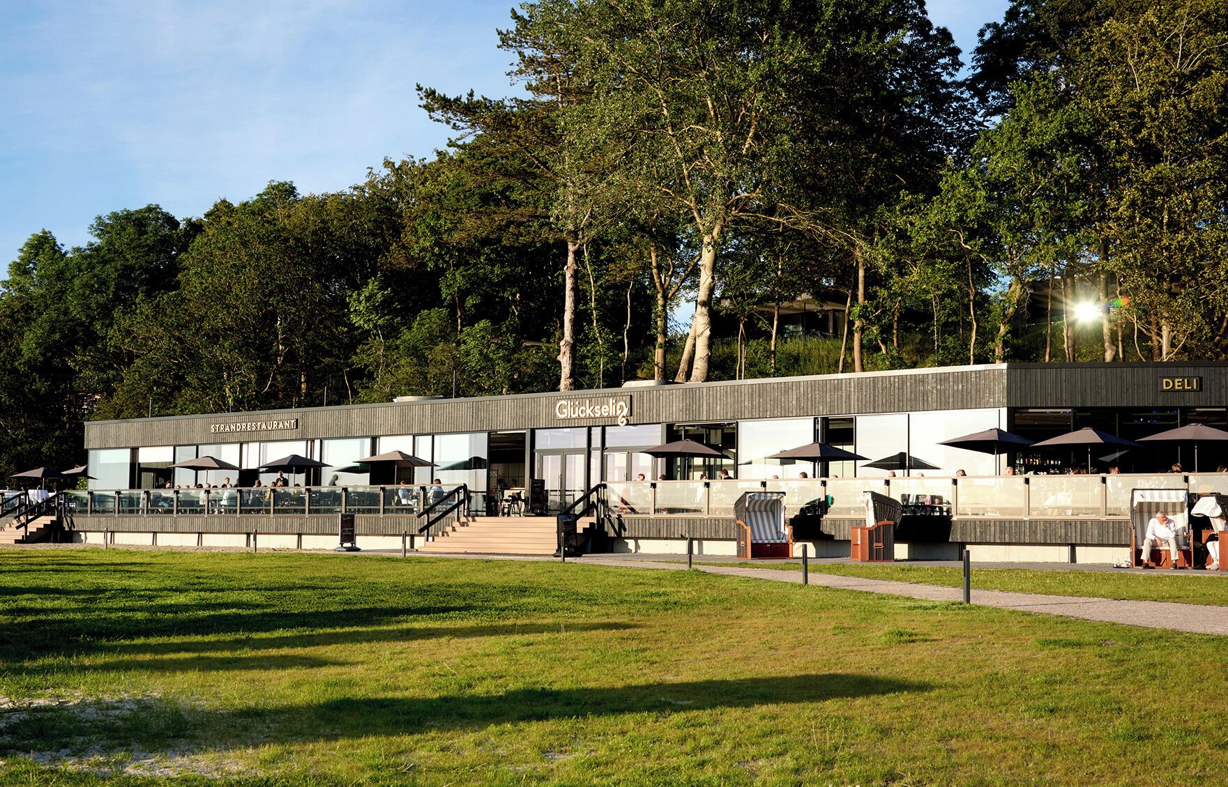 A modern outdoor restaurant with outdoor seating and a staircase leading to an upper level.