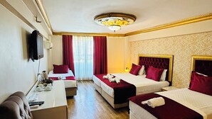 A hotel room with two beds, a desk, a television, and a window with curtains. - Marmara Deluxe Hotel (Istanbul)