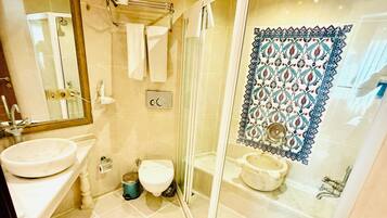 Ein Badezimmer mit Duschkabine, Waschbecken, Toilette und Spiegel.