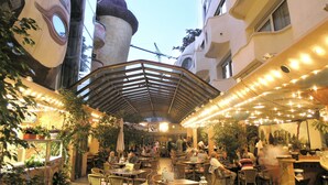 An outdoor café with tables and chairs, surrounded by buildings with unique architecture. - ALLVITALIS Traumhotel (Karlsruhe)