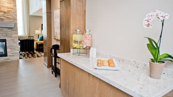 Una cocina moderna con encimera de mármol, estación de café y una orquídea en maceta.