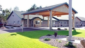 A two-story house with a covered patio and a stone exterior. - Crivitz Lodge (Crivitz)