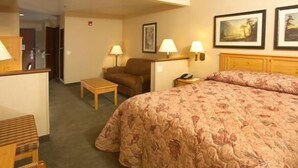 A hotel room with a bed, a desk, a chair, and two lamps. - Crivitz Lodge (Crivitz)