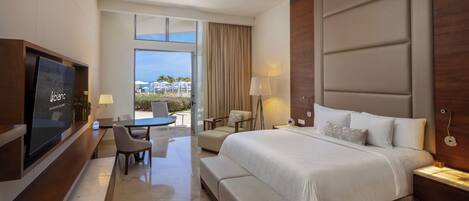 A modern hotel room with a large bed, a desk with a chair, a TV, and a balcony with a view.