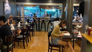 A restaurant with wooden floors, tables, and chairs. - Parvena Hotel (Bangkok)