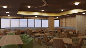 Ein Restaurantinneres mit mehreren Tischen und Stühlen, Deckenventilatoren und großen Fenstern mit Blick.