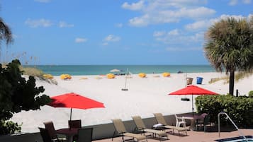 On the beach, white sand, beach cabanas, sun loungers