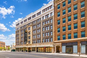 Un edificio de hotel histórico con varios pisos, ventanas amplias y un letrero destacado.