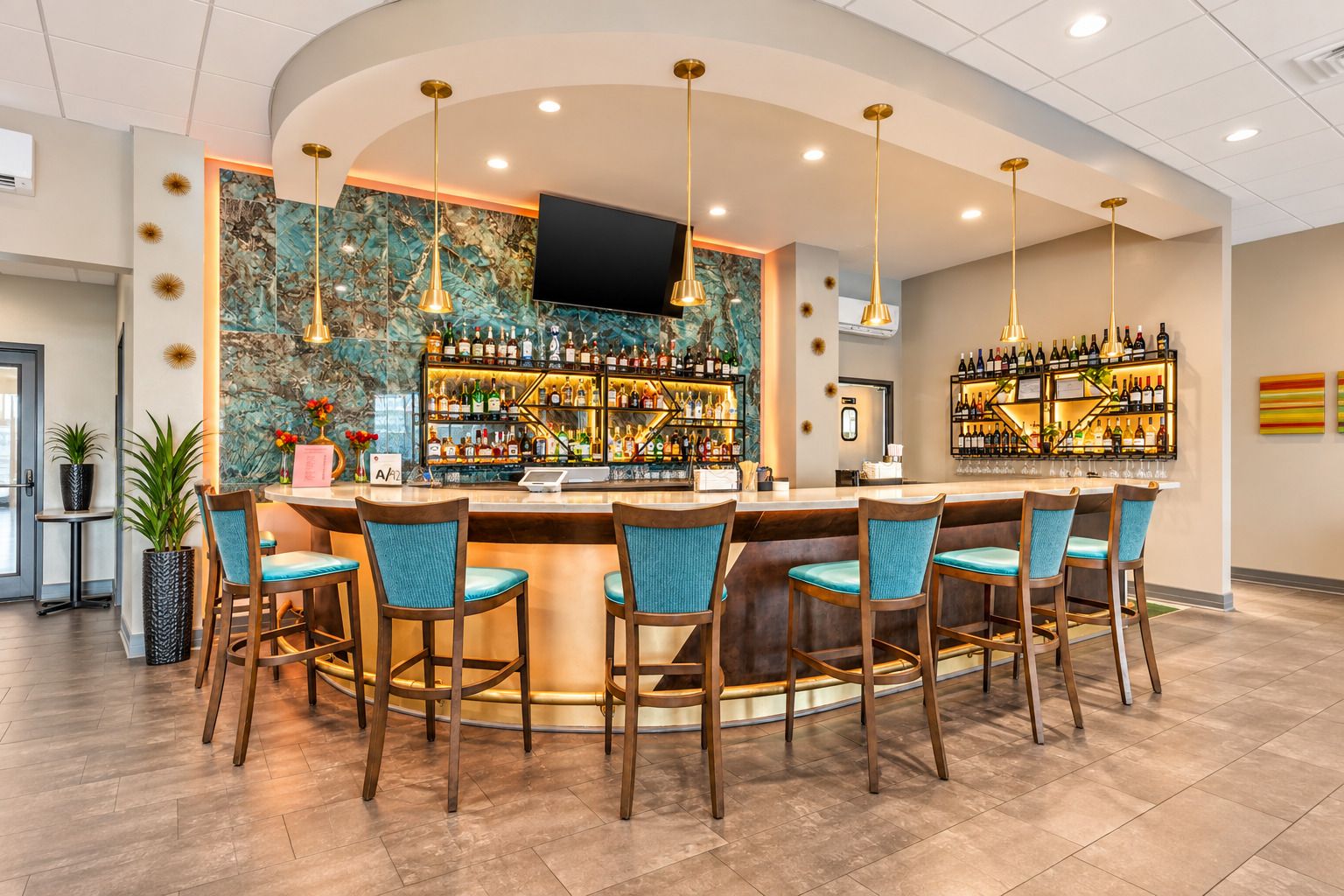 A bar area with a curved counter, multiple bar stools, and a variety of bottles and glasses.