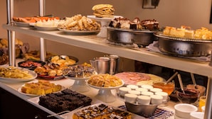 A buffet with various desserts and food items. - Pousada Betânia (Gramado)
