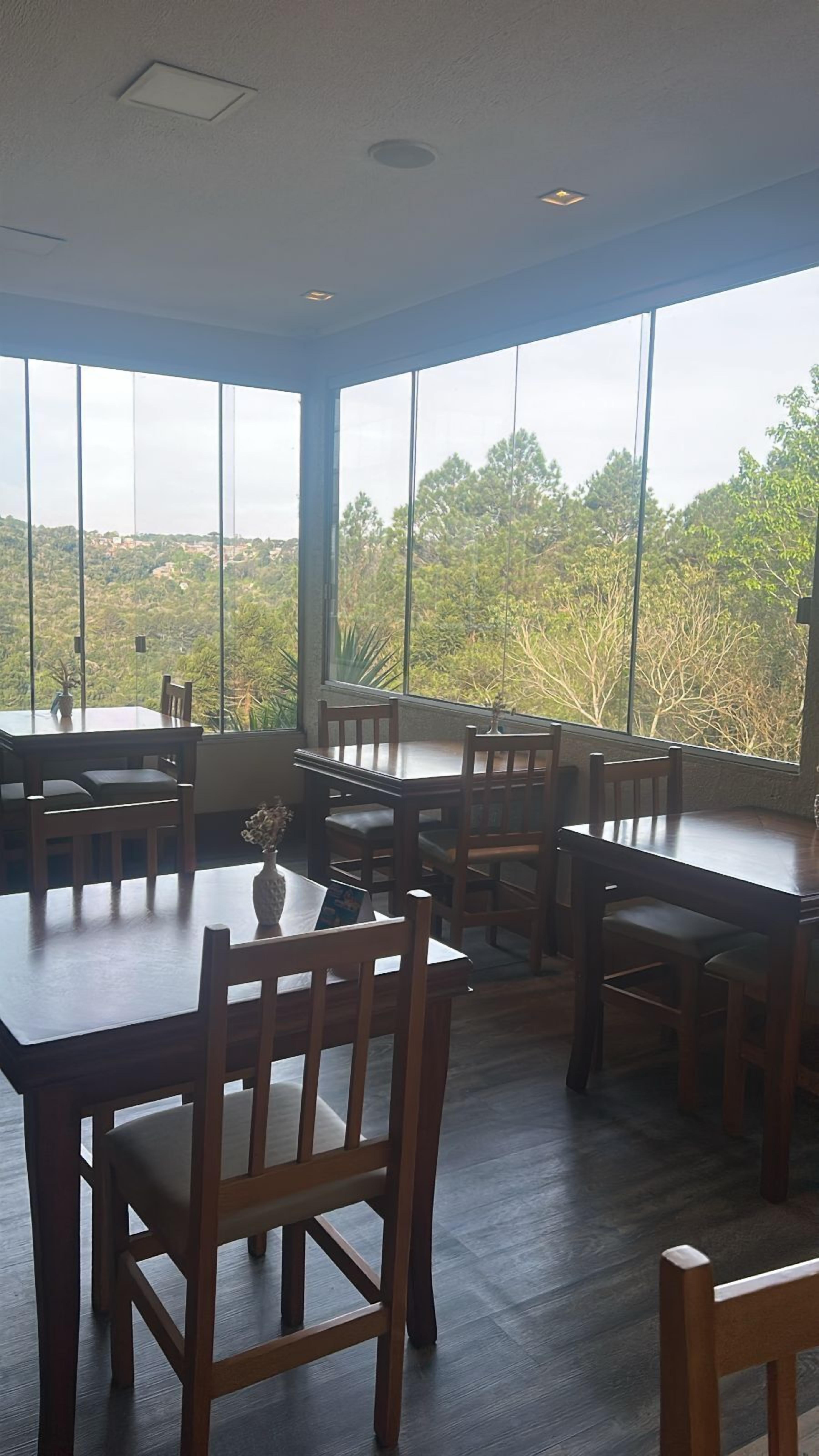 Une salle à manger spacieuse, dotée de grandes fenêtres qui offrent une vue sur le paysage environnant.