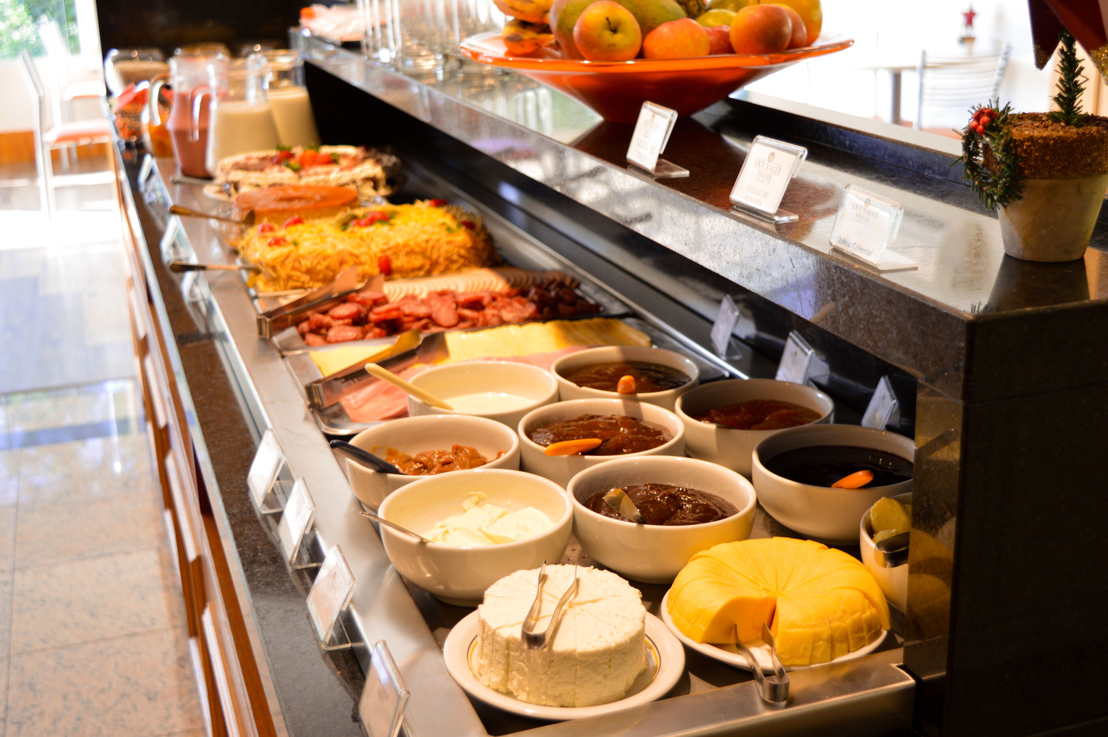 A buffet with various food items including fruits, cheeses, and meats.