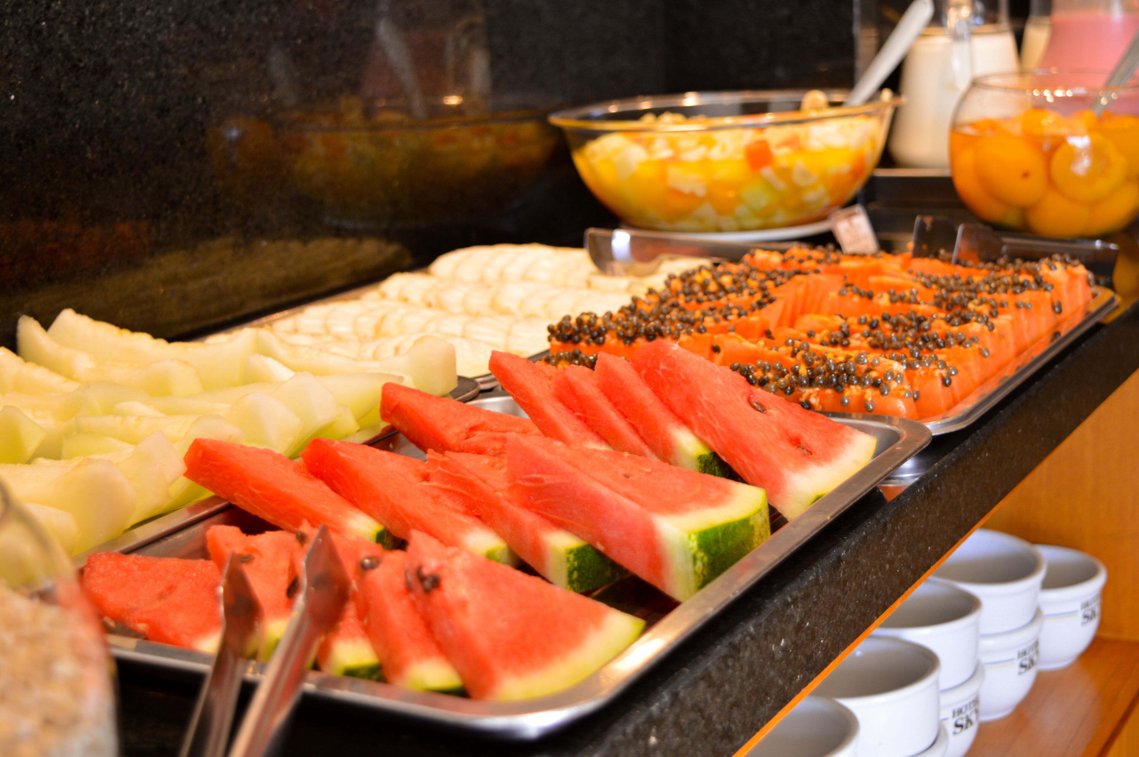 A buffet with various fruits and vegetables, including watermelon and carrots.