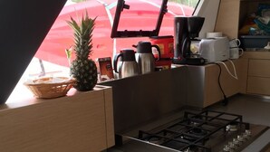Una cocina compacta con estufa a gas, cafetera y refrigerador pequeño.