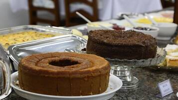 A buffet with various dishes including a bundt cake and a chocolate cake on a glass stand.