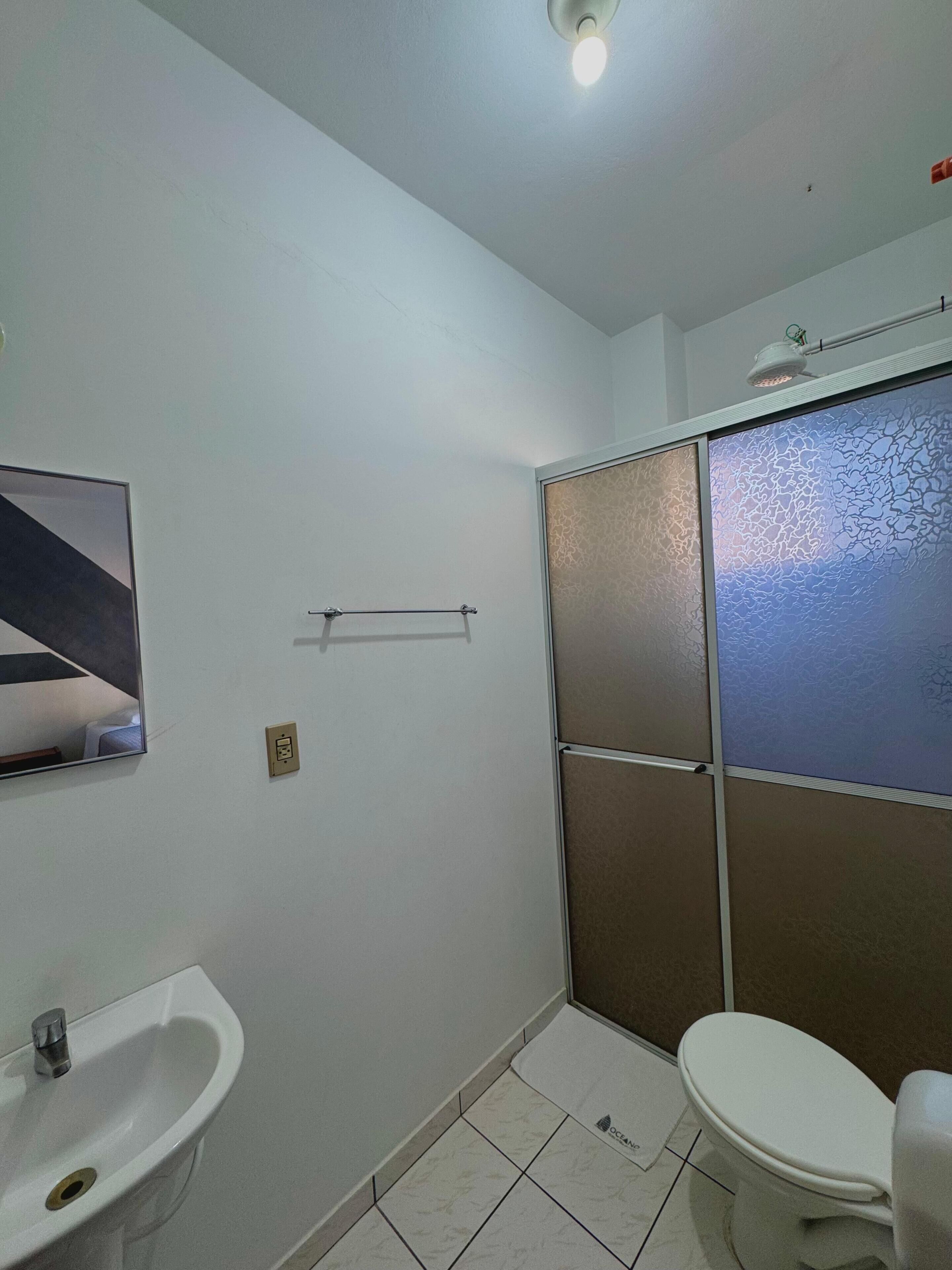 A bathroom with a sink, toilet, and shower.